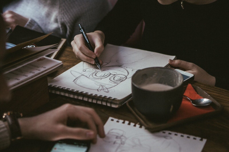 Artist drawing caricature across a table