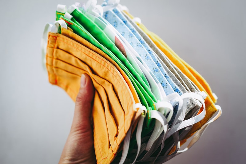 A bunch of coloured face masks in a hand